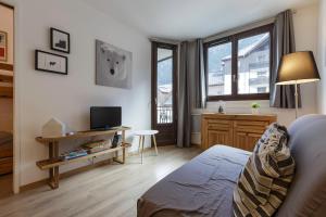 a bedroom with a bed and a desk with a tv at Les Marmottes En Chaussettes - Happy Rentals in Chamonix-Mont-Blanc