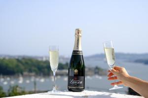 een fles champagne en twee glazen op een tafel bij Beautiful Cottage with Sea Views Cornwall in Saltash