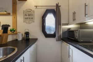 a kitchen with a sink and a microwave at Les Marmottes En Chaussettes - Happy Rentals in Chamonix-Mont-Blanc