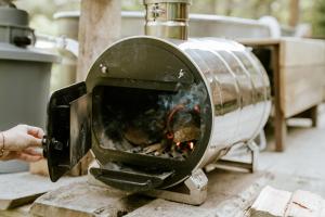 a person is cooking food in an oven at Les cabanes de roquehort in Salies-de-Béarn