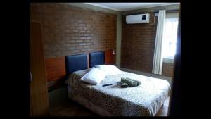 Un dormitorio con una cama y una pared de ladrillo. en Iguazú Apartments, en Puerto Iguazú 15 fotos más
