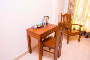 una scrivania in legno con sedia e tavolo in legno di Homestay Garden Rest Kandy a Kandy