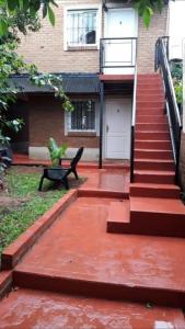 una casa con una escalera y un banco en el patio en Iguazú Apartments en Puerto Iguazú