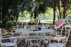 una mesa blanca con una botella de vino y 2 sillas en Villa Fazia, en Ortezzano