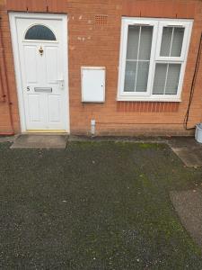 a house with a white door and two windows at 1 bed fully furnished Walsall property in Walsall