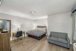 a bedroom with a bed and a desk and a chair at Rodeway Inn Stockton Highway 99 in Stockton