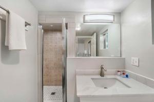 uma casa de banho branca com um lavatório e um chuveiro em Rodeway Inn Stockton Highway 99 em Stockton