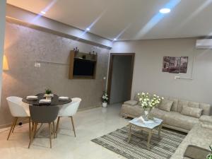 a living room with a table and a couch at Superbe appartement hautstanding in Sfax