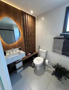 uma casa de banho com um WC, um lavatório e um espelho. em Studio novo, perto Allianz Park, ao lado do metrô em São Paulo