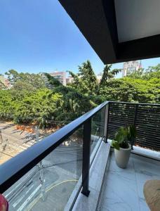 uma varanda com vista para uma rua e árvores em Studio novo, perto Allianz Park, ao lado do metrô em São Paulo