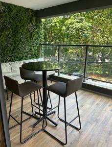 uma mesa de vidro e cadeiras sentadas numa varanda em Studio novo, perto Allianz Park, ao lado do metrô em São Paulo