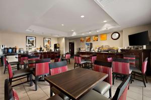 リノにあるComfort Inn & Suites Airport Convention Centerのテーブルと椅子のあるレストラン、バー