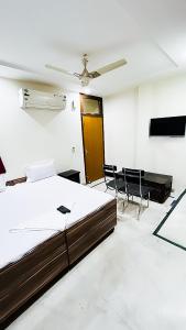 a bedroom with a bed and a ceiling fan at Govind puri residency in New Delhi