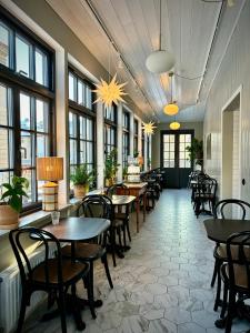 a restaurant with tables and chairs and windows at Hotell Esplanad in Växjö