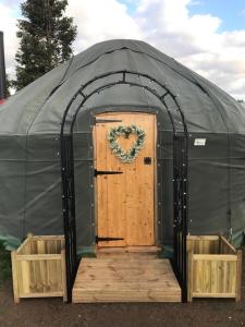 a gazebo with a door and a wreath on it at Lovely 1 bed Yurt in Salisbury in Salisbury