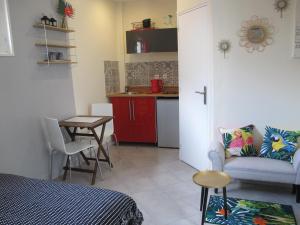 a room with a bed and a table and a kitchen at Studio avec cour extérieure in Bagnolet
