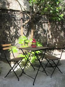 a table with two chairs and a tea kettle on it at Studio avec cour extérieure in Bagnolet