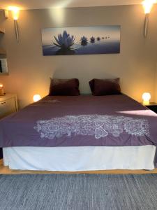 ein Schlafzimmer mit einem lila Bett mit zwei Kissen in der Unterkunft Le Jardin d'Isa in Chaumont-Gistoux