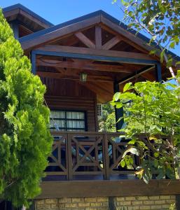 Casa con porche de madera con valla en Cabañas del Chachi en Oberá
