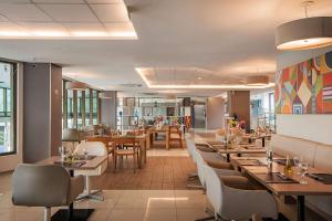 um restaurante com mesas e cadeiras de madeira e uma cafetaria em Wyndham Salvador Hangar Aeroporto em Salvador