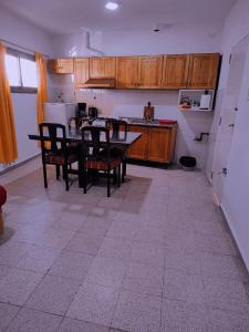 una cucina con armadi in legno, tavolo e sedie di Departamento céntrico en complejo privado a Godoy Cruz