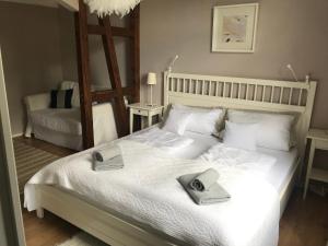 a bedroom with a white bed with two towels on it at Bergschlössl Herrenwies in Forbach