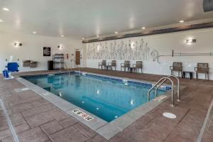 une grande piscine avec des chaises et une table dans l'établissement Sleep Inn & Suites Milwaukee-Franklin, à Franklin