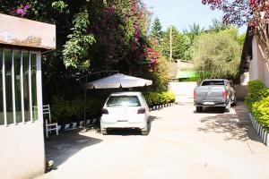 two cars parked in a driveway with an umbrella at Kind private room 8 in Addis Ababa