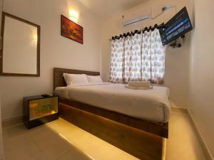 a bedroom with a large bed and a window at Le Poshe Luxury Pondicherry in Puducherry