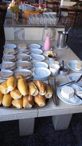 uma mesa com pratos de pão e tigelas de comida em Roma Hotel em Porto Alegre