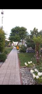 einen Gehweg in einem Garten mit Blumen und Bäumen in der Unterkunft Domki u Beaty in Rewal