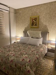 - une chambre dotée d'un lit avec un couvre-lit floral dans l'établissement Superbe appartement hautstanding, à Sfax