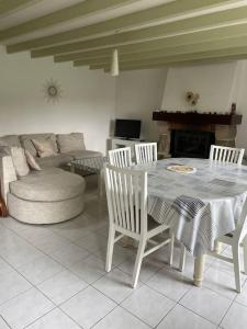 Maison en pierre, proche Keravel, GR34 في Pléguien: غرفة معيشة مع طاولة وكراسي وأريكة