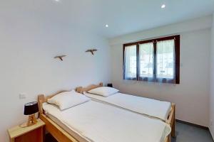 2 Betten in einem weißen Zimmer mit Vögeln über ihnen in der Unterkunft CASA-Bruno family chalet Queyras 7p in Aiguilles
