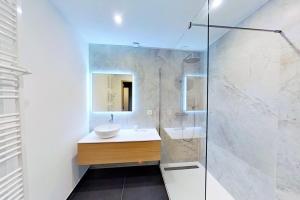 ein Bad mit einem Waschbecken und einer Glasdusche in der Unterkunft CASA-Le Cherk Chalet 300m2 jacuzzi sauna Vars les Claux in Vars