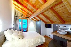 ein Schlafzimmer mit einem weißen Bett und einem Waschbecken in der Unterkunft CASA-Le Cherk Chalet 300m2 jacuzzi sauna Vars les Claux in Vars