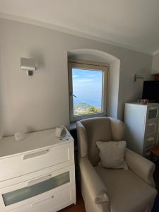 een woonkamer met een bank en een raam bij LA FINESTRA SUL MARE in Camogli