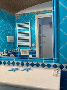 een blauwe badkamer met een wastafel en een spiegel bij LA FINESTRA SUL MARE in Camogli