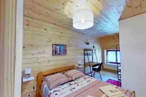 a bedroom with a wooden wall with a bed and a ladder at CASA-La Fuste center St-Véran foot of the slopes 6p in Saint-Véran