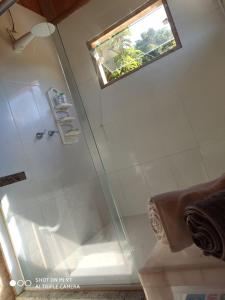 a shower with a glass door in a bathroom at Chalés do GreenGo in Santo Antônio do Pinhal +75 photos