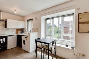 cocina con mesa, fregadero y ventana en Remarkable 1-Bed Studio in Hayes en Hayes