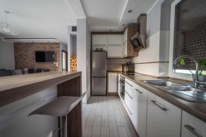 a kitchen with white cabinets and a sink at Kaszubska Ostoja in Ostrowite