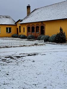 una casa con nieve en el suelo delante de ella en Csodarét Kúria, en Mórahalom