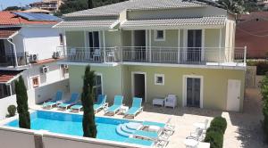 a villa with a swimming pool in front of a house at The Central Suites in Kassiopi