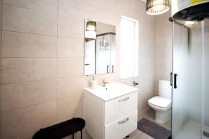 y baño con lavabo, aseo y espejo. en Casa Pássaro en Vila Franca de Xira