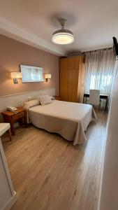 um quarto com uma cama grande e uma mesa em Hostal Atienzar em Albacete