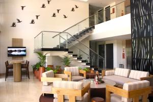 a living room with a staircase and furniture at Hotel Morúa in Yopal