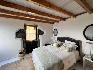 a bedroom with a bed and a window at Waka Waka Pico Azores in Cais do Pico