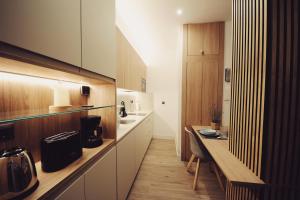 eine Küche mit weißen Schränken und einer Holztheke in der Unterkunft The Park House II by homebilbao. in Bilbao