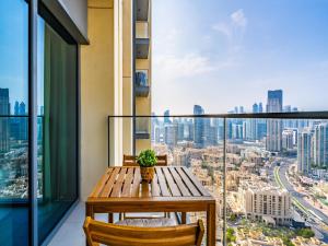 a wooden table and chairs on a balcony with a view at Exquisite 2BR w/ Breathtaking Burj Khalifa Skyline in Dubai